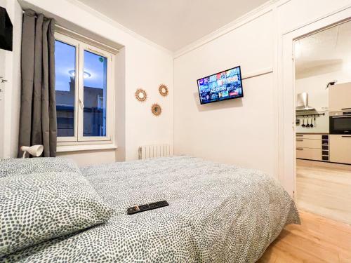 a bedroom with a bed and a tv on the wall at **Nouveau** Le Spacieux au coeur de Guingamp in Guingamp