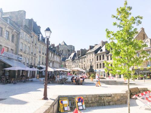a city street with tables and chairs and a tree at **Nouveau** Le Spacieux au coeur de Guingamp in Guingamp