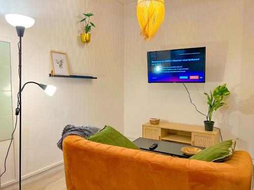 a living room with a couch and a tv at **Nouveau** Le Spacieux au coeur de Guingamp in Guingamp