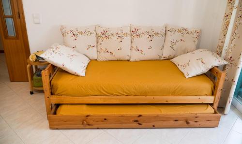 a wooden bed with two pillows on top of it at Casa da Cerca Ferragudo Beach Caves Hiking Golf in Ferragudo