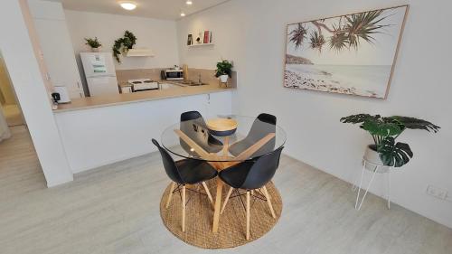 a dining room with two chairs and a table at The Noosa Apartments in Noosa Heads