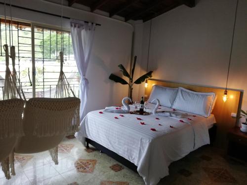 a bedroom with a white bed and a large window at Magic Jardín Hostel in Jardin