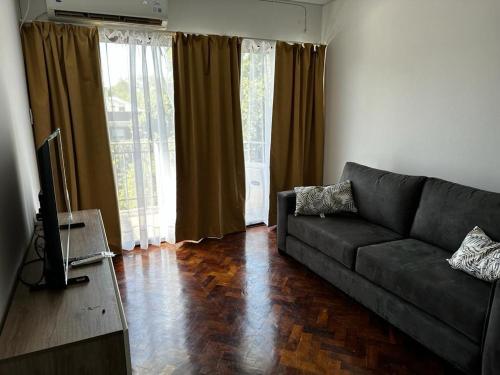 sala de estar con sofá y TV en Prunus en Mendoza