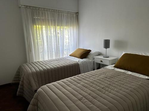 1 dormitorio con 2 camas y ventana en Prunus en Mendoza