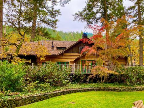 a log cabin in the woods with a yard at Weasku Inn in Grants Pass
