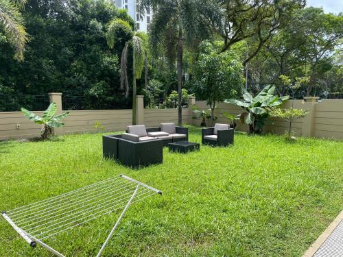 花园别墅 في سنغافورة: حديقة فيها كنب وكراسي في العشب
