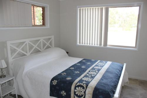 a white bedroom with a bed and a window at 2 51 Carlo Road Rainbow Beach in Rainbow Beach
