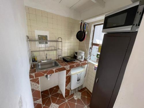 a small kitchen with a sink and a refrigerator at Departamento Naval Coyoacán in Mexico City