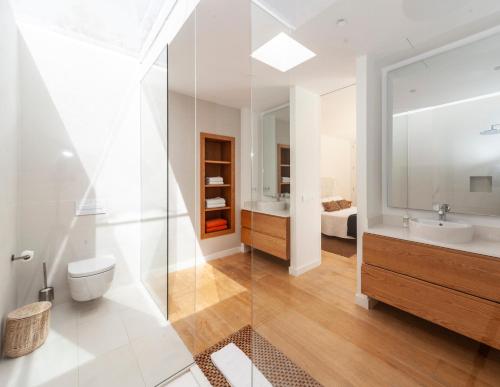 ein Badezimmer mit einem WC, einem Waschbecken und einem Spiegel in der Unterkunft Luxury Casa El Marques in Puerto del Carmen