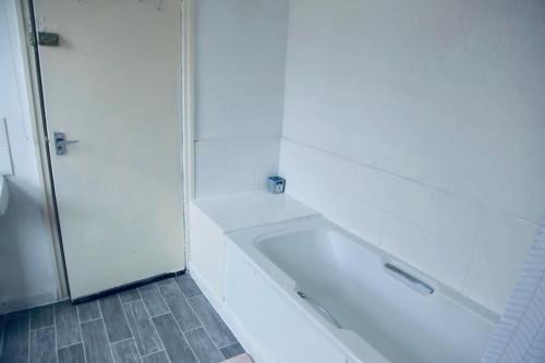 a white bathroom with a tub and a shower at A PEACEFUL DOUBLE BEDROOM IN LEEDS in Hunslet