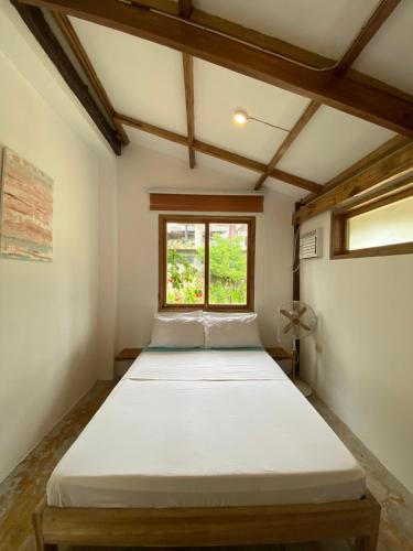 a bedroom with two beds in a room with a window at Secret Spot Siargao in General Luna