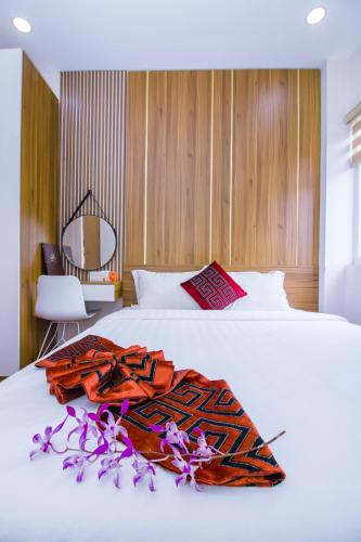 a bed with a blanket on top of it at Anh Thảo Hotel Quy Nhơn in Quy Nhon