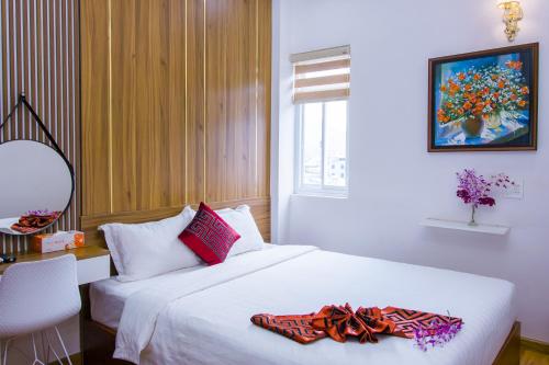 a bedroom with two beds and a desk and a window at Anh Thảo Hotel Quy Nhơn in Quy Nhon