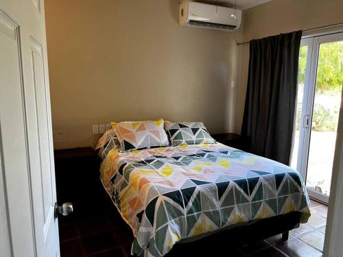 1 dormitorio con 1 cama con un edredón colorido en FREE CAR W/ Private House & Ocean View, en El Bedito