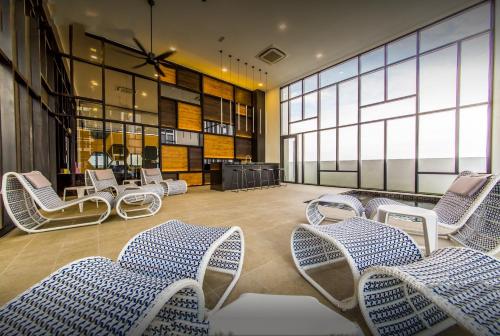 a waiting area with chairs and tables in a building at Duplex Town House at EcoBotanic Near Legoland with Netflix and KTV System in Nusajaya