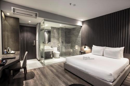a bedroom with a large white bed and a bathroom at Grand Ocean Luxury Boutique - Infinity Rooftop Pool in Da Nang