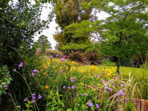 a garden with flowers and trees in the background at Las Macluras Tandil Casa de Campo in Tandil