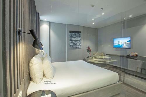 a bedroom with a bed and a tv on a wall at Grand Ocean Luxury Boutique - Infinity Rooftop Pool in Da Nang