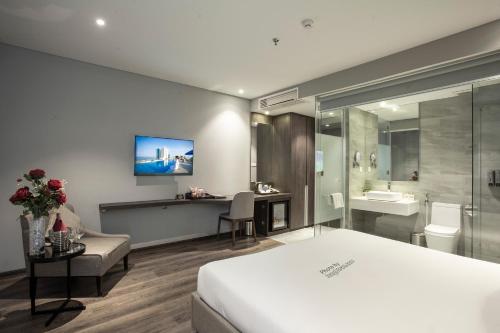 a hotel room with a bed and a bathroom at Grand Ocean Luxury Boutique - Infinity Rooftop Pool in Da Nang