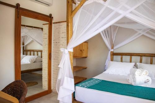 a bedroom with two bunk beds and a mirror at Pousada Paraiso dos Ventos Preá in Prea