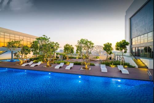 a hotel with a swimming pool in front of a building at Duplex Town House at EcoBotanic Near Legoland with Netflix and KTV System in Nusajaya