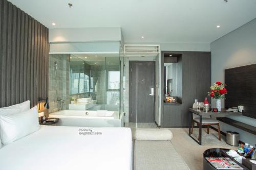 a bedroom with a bed and a bathroom with a tub at Grand Ocean Luxury Boutique - Infinity Rooftop Pool in Da Nang