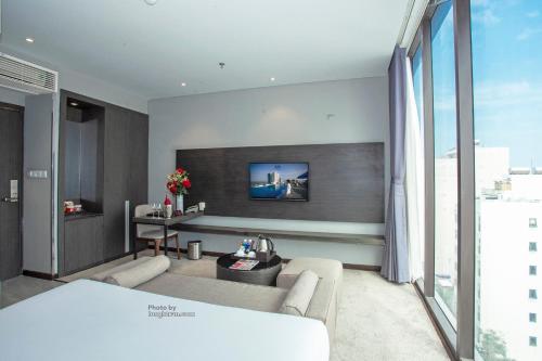 a living room with a couch and a large window at Grand Ocean Luxury Boutique - Infinity Rooftop Pool in Da Nang