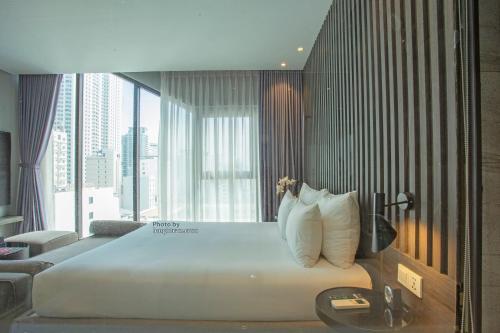 a large bed in a room with a large window at Grand Ocean Luxury Boutique - Infinity Rooftop Pool in Da Nang