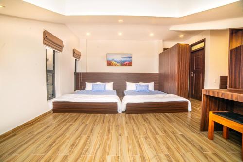 a bedroom with two beds and a television at KP Villa Dalat in Da Lat