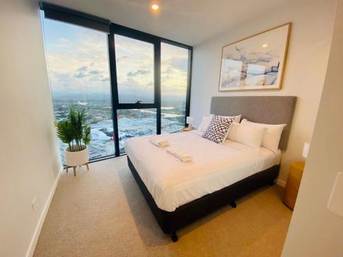 a bedroom with a bed and a large window at Luxury 2 bedrm apartment in Broadbeach- Be a Star in Tower One of the casino 2 bedroom apartment 334F in Gold Coast