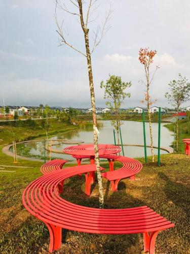 a red picnic table and a tree in a park at Elmina near Denai Alam, Saujana Utama with Wi-Fi & Netflix in Shah Alam