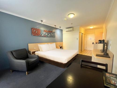 Pokój hotelowy z łóżkiem i krzesłem w obiekcie Stay at Alice Springs Hotel w mieście Alice Springs