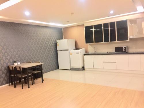 a kitchen with a table and a refrigerator at iCheck inn Residence Sukhumvit 1 in Bangkok