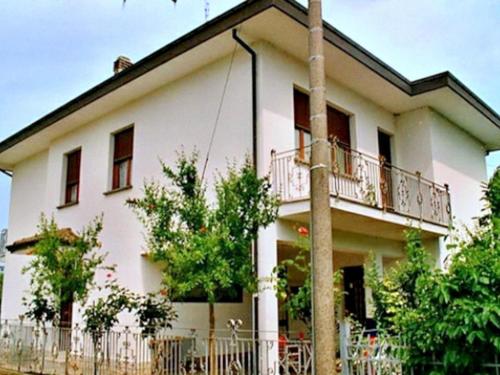 a white house with a fence in front of it at Belvilla by OYO Venturi Cherry in Gatteo a Mare