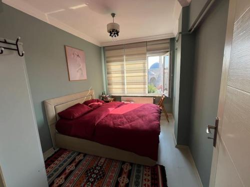 a bedroom with a red bed and a window at Live in Fatih, live Istanbul in Istanbul