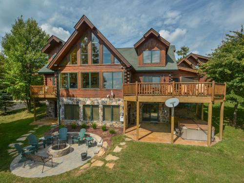 a large wooden house with a deck and chairs at Highlands Heaven in McHenry