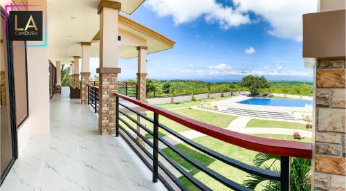 a house with a balcony with a view of a pool at La Candura in Siquijor