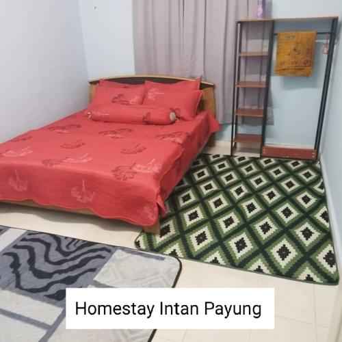 Schlafzimmer mit einem Bett mit roter Bettwäsche und einer Leiter in der Unterkunft Homestay Intan Payung Mitc in Ayer Keroh