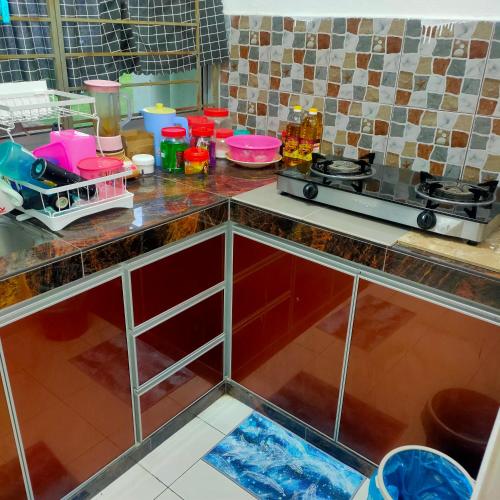 uma cozinha com uma bancada com um fogão em Homestay Intan Payung Mitc em Ayer Keroh