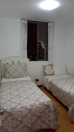 - une chambre avec 2 lits et une fenêtre dans l'établissement Dpto. con piscina en San Miguel, à Lima