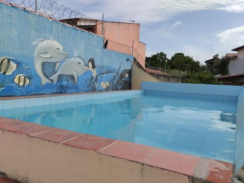 a mural of dolphins on a wall next to a swimming pool at Apartamento Icaraí prox ao cumbuco in Caucaia