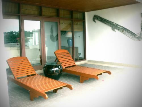 two orange chairs sitting on a porch with a pot at Blue Canyon Country Club in Mai Khao Beach