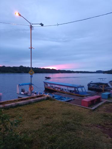 a couple of boats docked on the water at dusk at Apartamentos Caimán Tortuguero in Tortuguero