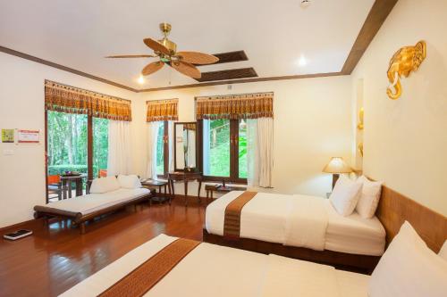 a bedroom with two beds and a ceiling fan at Panviman Chiang Mai Spa Resort in Mae Rim
