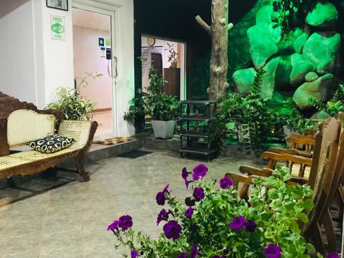ein Wohnzimmer mit lila Blumen und Pflanzen in der Unterkunft Pinidiya Resort in Anuradhapura