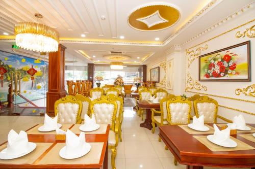 a restaurant with tables and chairs and a chandelier at Anh Thảo Hotel Quy Nhơn in Quy Nhon