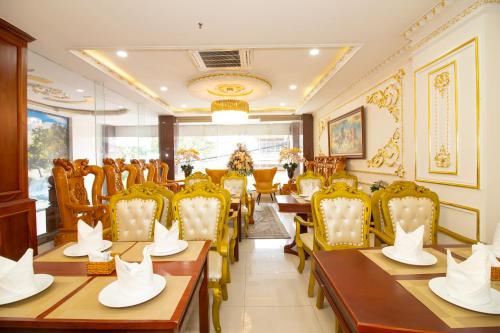 een restaurant met houten tafels en gele stoelen bij Anh Thảo Hotel Quy Nhơn in Quy Nhon