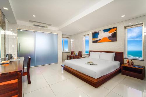 a bedroom with a large bed and a desk and a desk at Hotel Soco in Da Nang