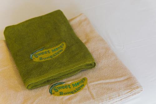 two green towels sitting on top of a towel at Sweet Mango Khaolak in Khao Lak