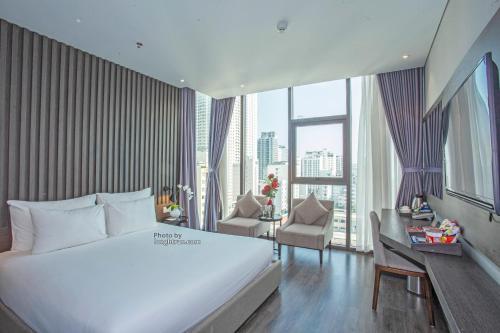 Habitación de hotel con cama, escritorio y ventana en Grand Ocean Luxury Boutique, en Da Nang
